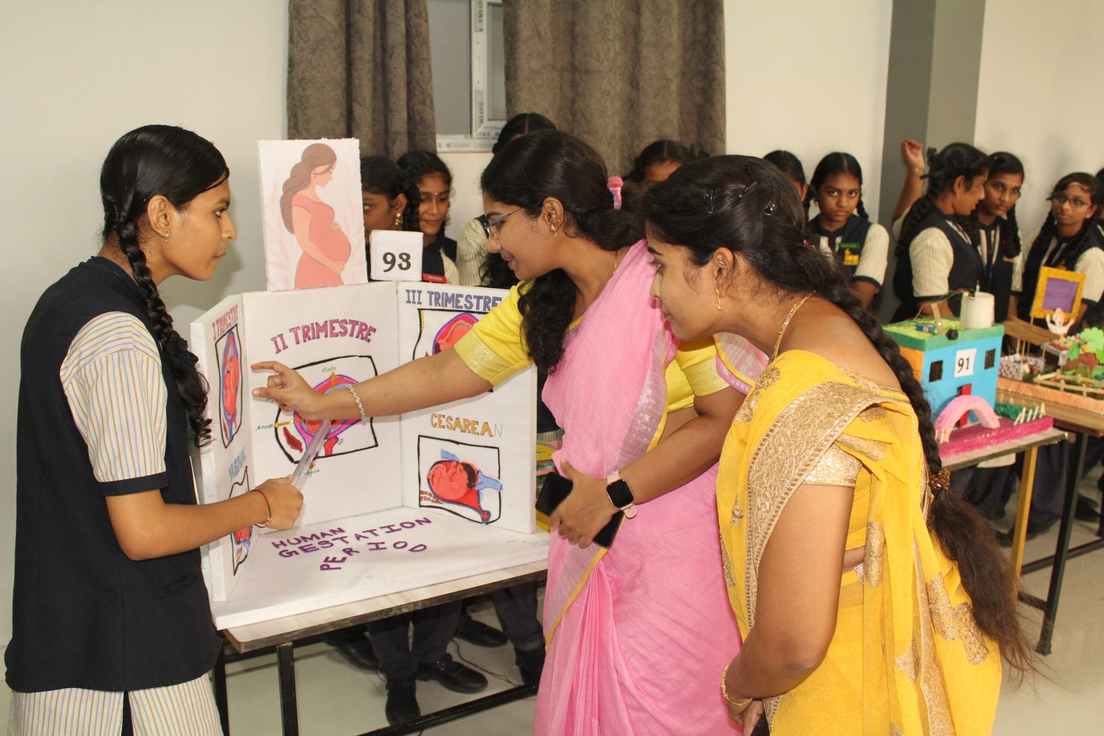 A Saiteja Vidyaniketan student explaining her educational exhibition project to teachers